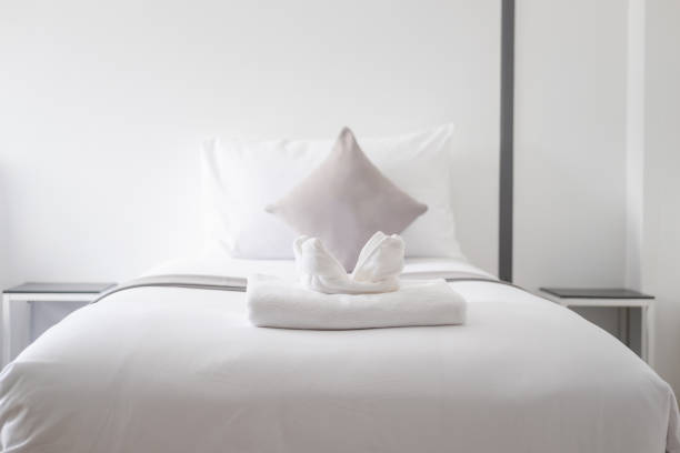 istock White fresh towel on single bed in bedroom 968953306