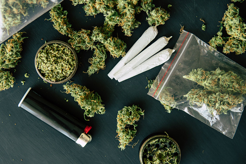 Cannabis Joint And A Packet Of Weed And Smartphone On A Black Wood  Background Bud Of Marijuana Flowers On Scales Grinder And Shredded Stock  Photo - Download Image Now - iStock