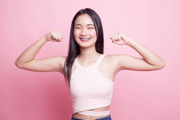 istock Beautiful young Asian woman flex bicep. 968957000