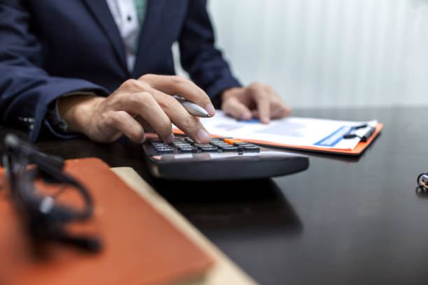 istock Man using calculator and writing make note with calculate in the office and Monitoring financial information 968959398
