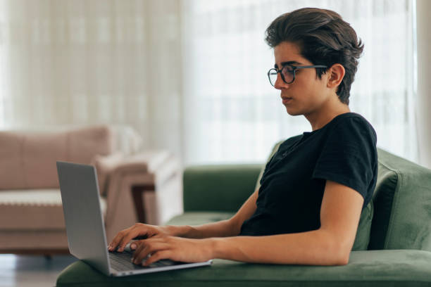 istock Teenage boy using laptop at home 968964250