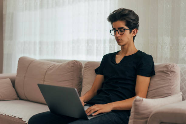 istock Teenage boy using laptop at home 968964280