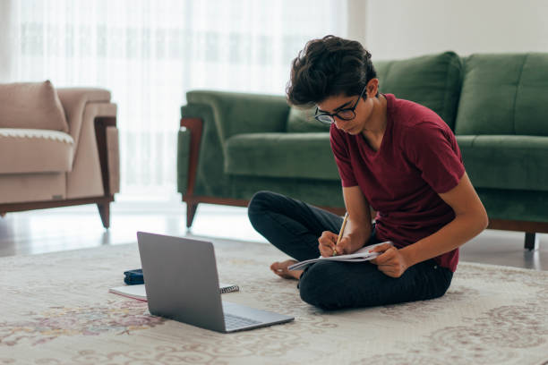 männlicher teenager, die hausaufgaben mit laptop und - nerd computer learning fun stock-fotos und bilder