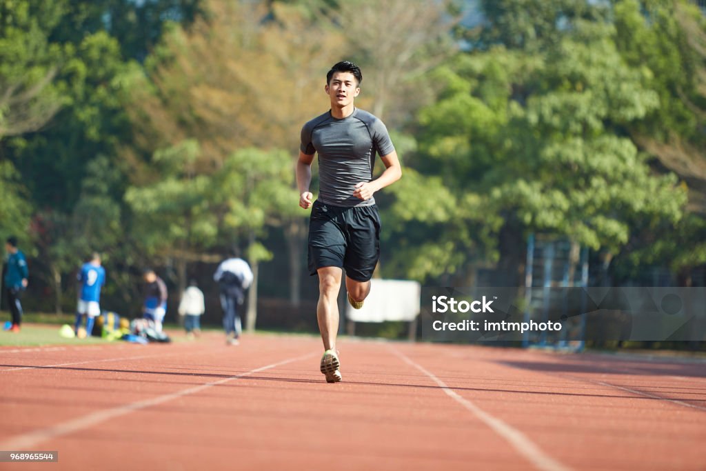 jovem atleta asiática treinando na pista de corrida - Foto de stock de Correr royalty-free