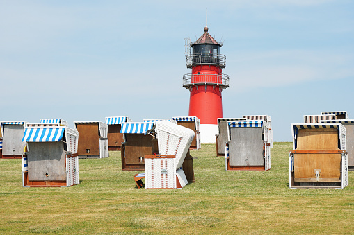dike with hooded beach chairs and lighthouse