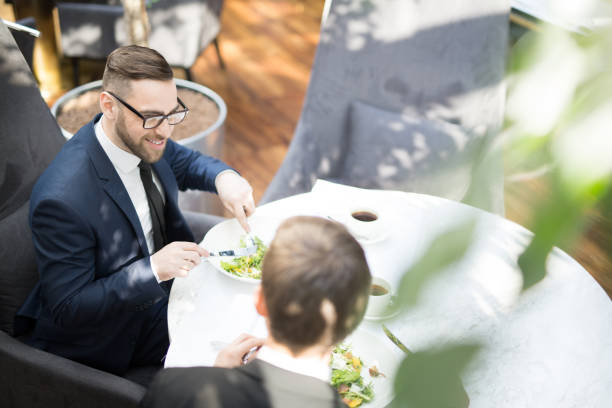 Lunch of businessmen Businessman and his colleague talking by lunch in modern restaurant at break business lunch stock pictures, royalty-free photos & images