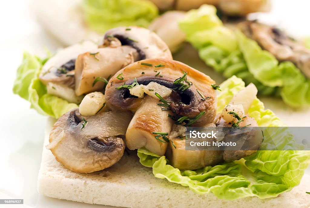 Delicious fresh vegetable panini Mushroom with lettuce leaf on panini slice as closeup Edible Mushroom Stock Photo