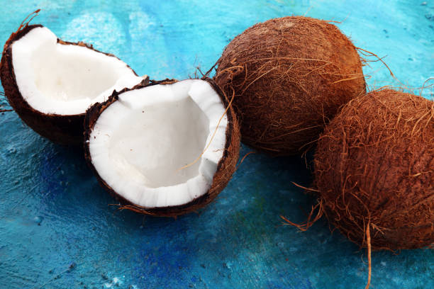 istock Ripe half cut coconut on a blue background 968969658