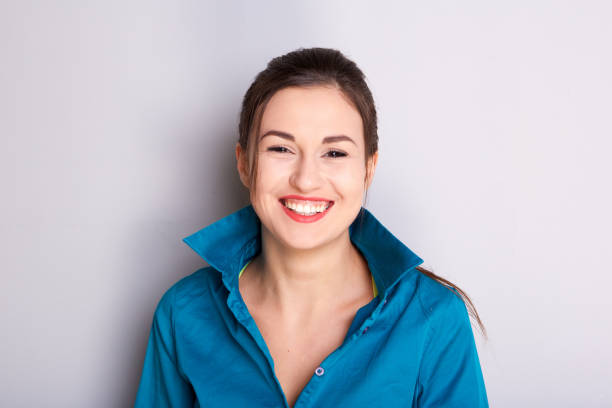 istock Close up smiling young woman against gray background 968972720