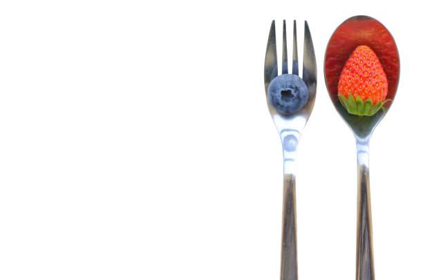 istock Strawberry and blueberry on spoon and fork with white background. 968972948