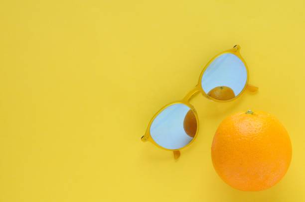 istock Slice orange fruit and yellow sunglasses on yellow background. 968973214