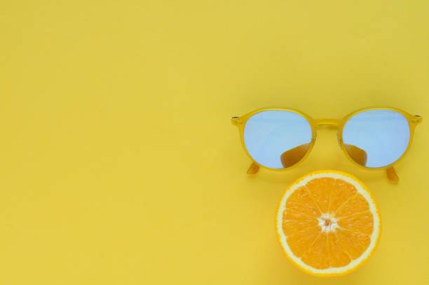 istock Slice orange fruit and yellow sunglasses on yellow background. 968973334