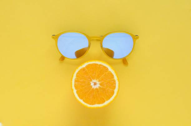 istock Slice orange fruit and yellow sunglasses on yellow background. 968973340