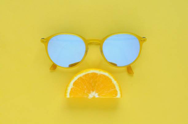 istock Slice orange fruit and yellow sunglasses on yellow background. 968973600