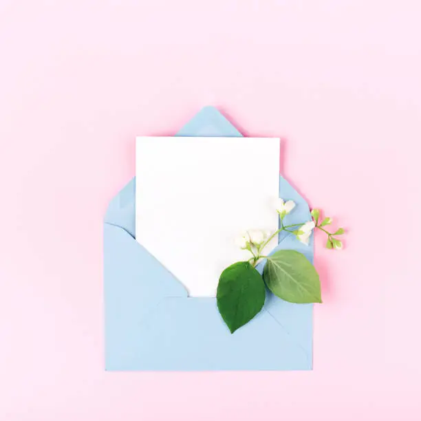 Photo of Mockup with envelope and flower on pink background.