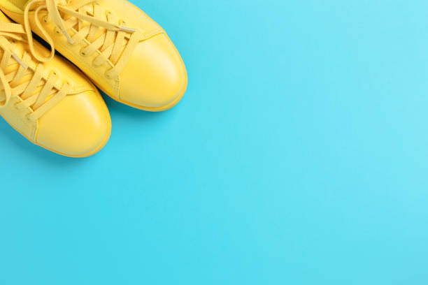istock Pair of yellow shoes on blue background. 968976848