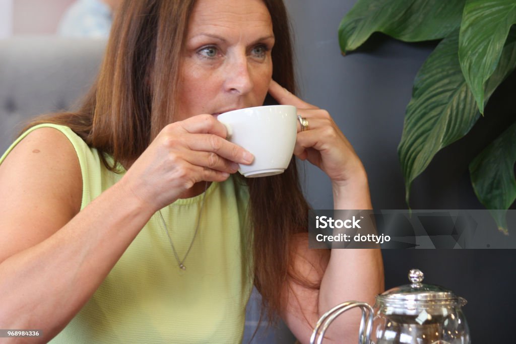 A lady sitting alone Sitting alone in a tea shop deep in thought 45-49 Years Stock Photo