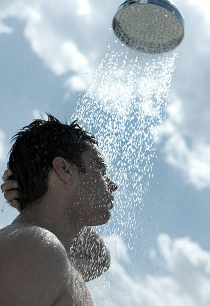 Man taking outdoor shower stock photo