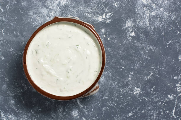 salsa greca di tzatziki su sfondo grigio. la vista dall'alto, piatta giaceva. - condimento per insalata foto e immagini stock