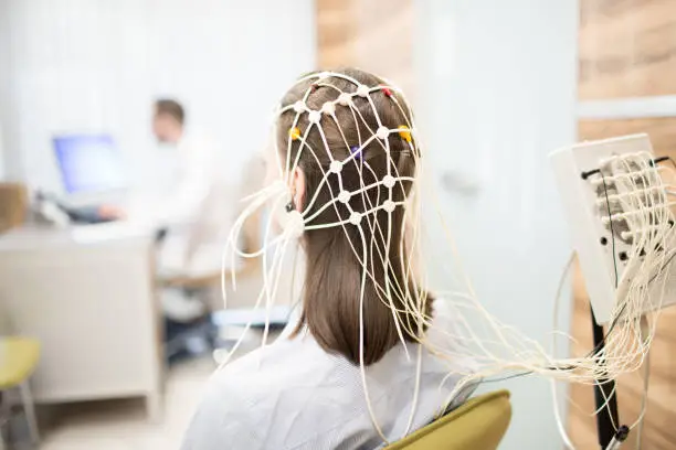 Back view of patient with eeg equipment on her head during brain activity clinical test