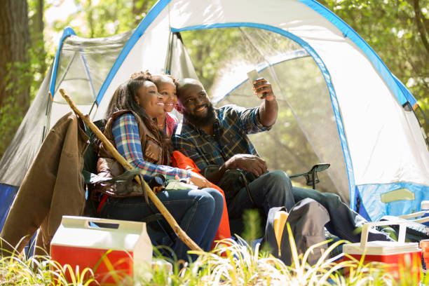 istock Family on summer or autumn vacation camping in forest. 968990280