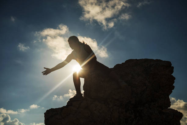 istock Woman giving help hand at hill peak 968993476