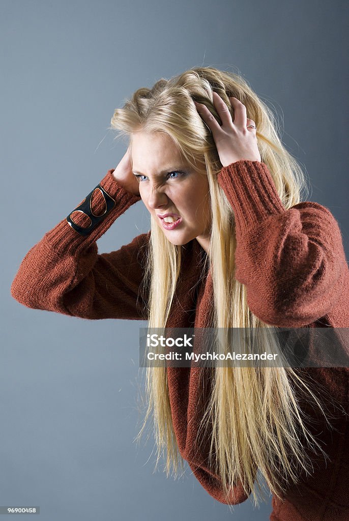 blond girl furiously scratches her tangled hair  16-17 Years Stock Photo