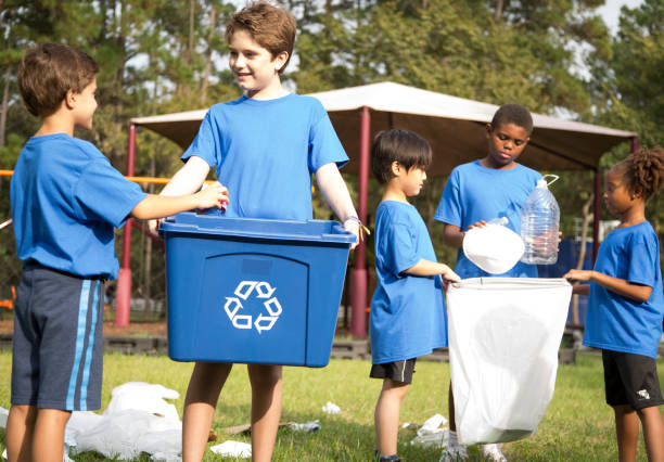 istock Multi-ethnic group of school children recycling at park. 969004592