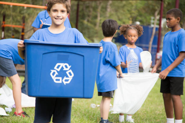 istock Multi-ethnic group of school children recycling at park. 969005010