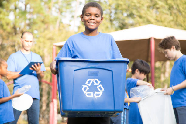 multi-ethnic group of school children recycling at park. - wasting time imagens e fotografias de stock