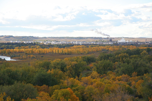 View of Missouri River at Bismarck overlook in autumn with Mandan Refinery in background.