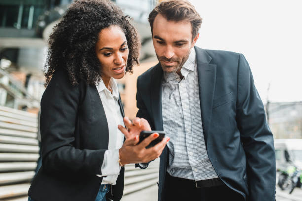 istock Businesspeople looking at smart phone and talking 969013740