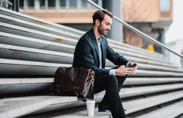 istock Businessman taking a break and using smart phone on the stairs 969013756