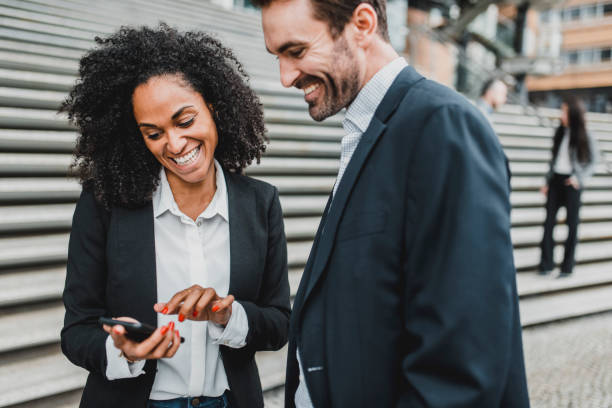 istock Businesspeople looking at smart phone and talking 969013804