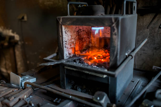 istock Blacksmith furnace with red hot metal workpiece. 969015246