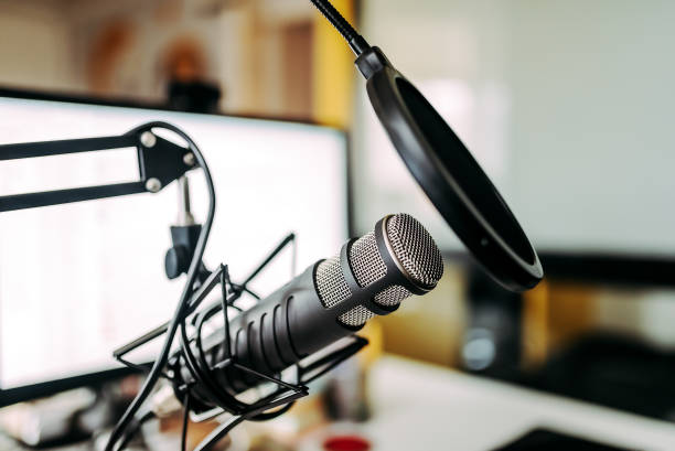 istock Close-up image of microphone and white computer screen in the background. 969015294