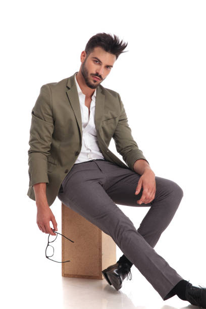 istock relaxed stylish man with open collar sitting on wooden box 969031700