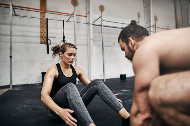 istock Fit young man helping his female gym partner do crunches 969035052