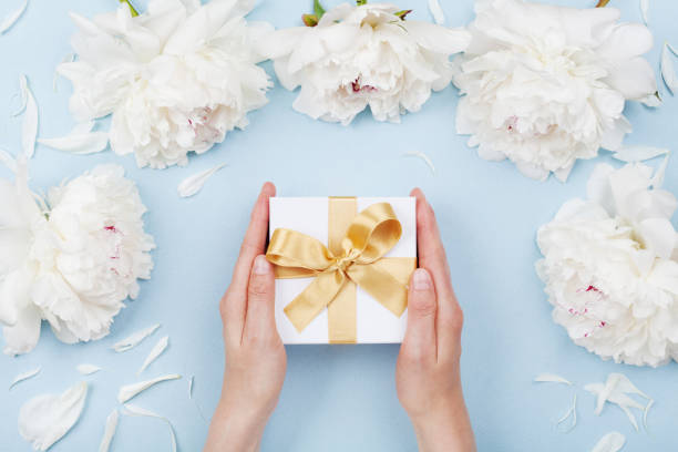 mujer manos dar regalo o presente caja decoración flores de peonía blanca vista de pastel mesa. lay flat para cumpleaños o boda. - table wedding flower bow fotografías e imágenes de stock