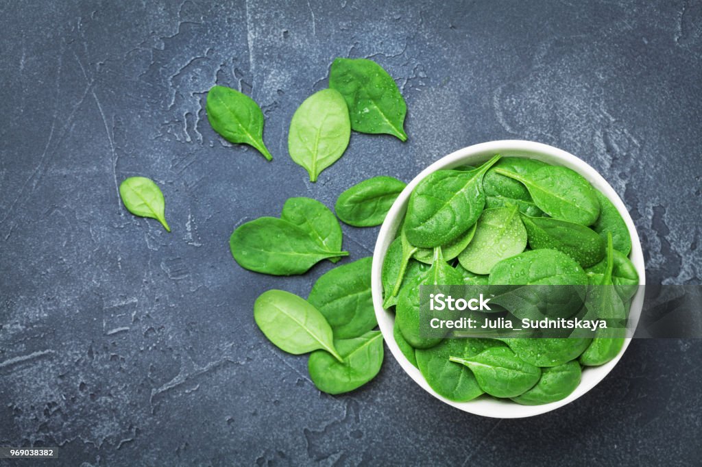 Feuilles d’épinards verte dans un bol sur la vue de dessus de tableau noir. Organique et régime alimentaire. - Photo de Épinard libre de droits