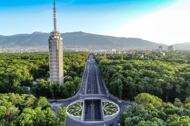 Drone shot of traffic circle and radio tower in the middle of a beautiful city forest. The scene is situated in Sofia, the capital city of Bulgaria (Eastern Europe). The picture is taken with DJI Phantom 4 Pro video drone.