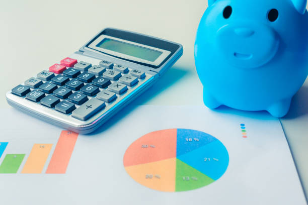 istock Piggy bank, calculator and financial documents with graphics data 969048036