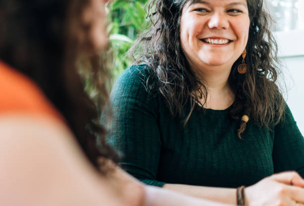 istock Two sisters or siblings having a discussion at a table and listening with a smile 969048758