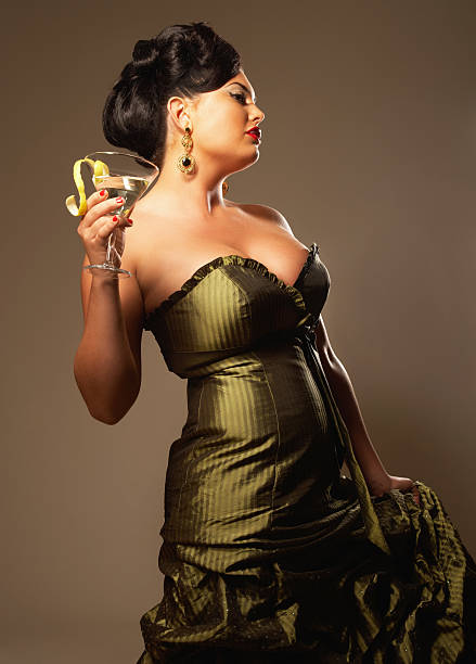 Woman Holding Martini Glass and Wearing Evening Gown stock photo