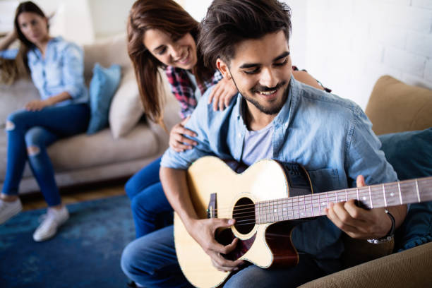 istock Young handsome man playing guitar for his girlfriend 969052880