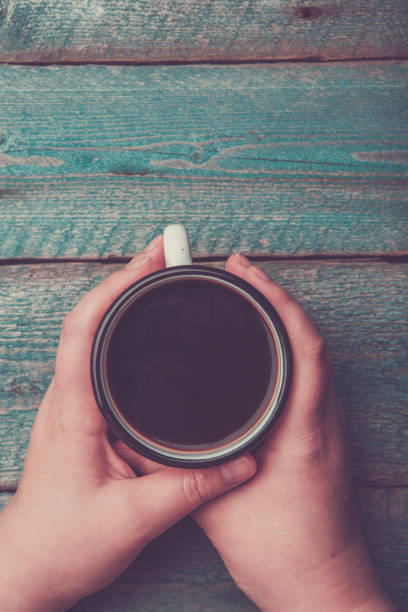 istock a woman holding in hand white iron mug 969066572