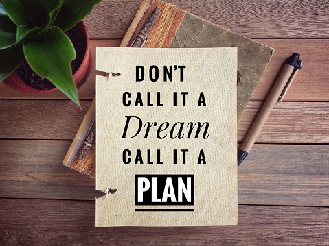 ‘Don’t call it a dream, call it a plan’ written on a paper. Vintage styled background.