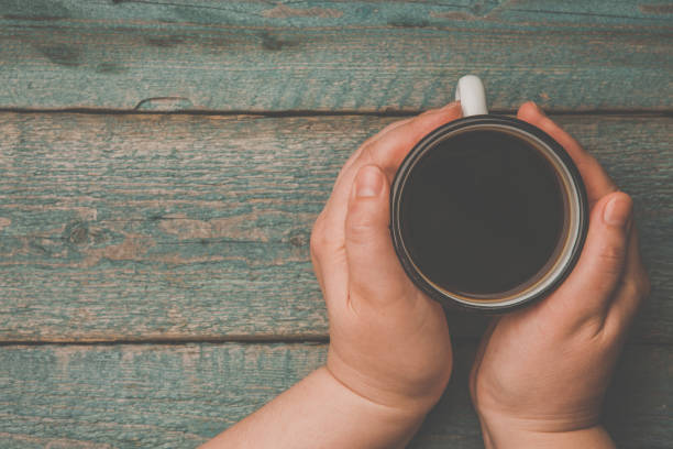 istock a woman holding in hand white iron mug 969066652