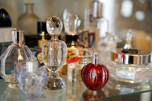 Colorful perfume glass bottles on shelf with various shapes and sizes