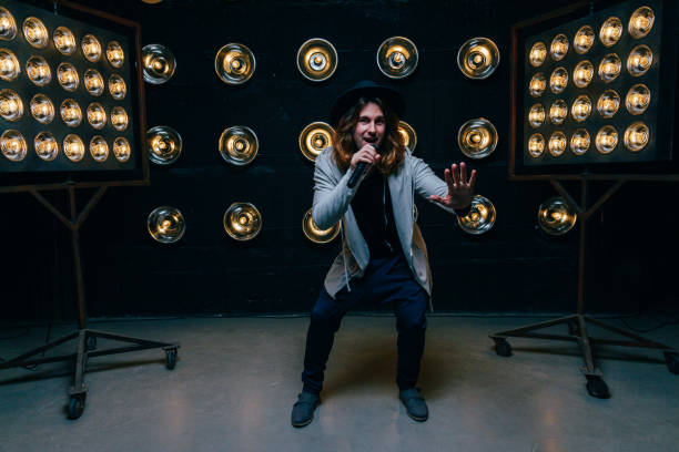 istock men singer with long hair, with microphone on the stage 969086344